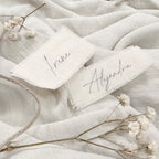 Marcador de sitios de algodón Novellie, con diseño decorativo y suave textura para marcar lugares en eventos o reuniones.