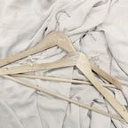 Percha esencia Novellie de madera con diseño elegante para colgar prendas y accesorios en armario.