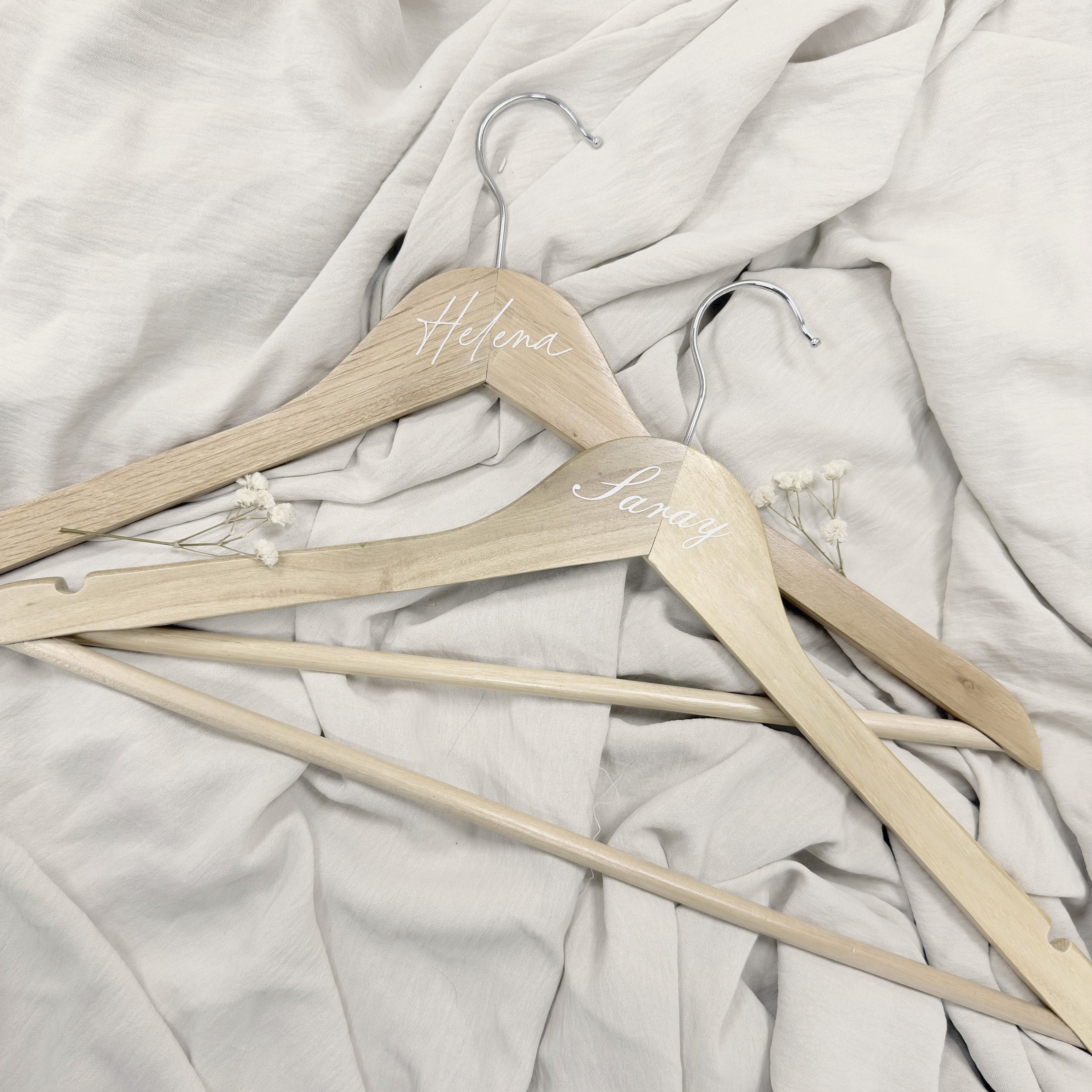 Percha esencia Novellie de madera con diseño elegante para colgar prendas y accesorios en armario.