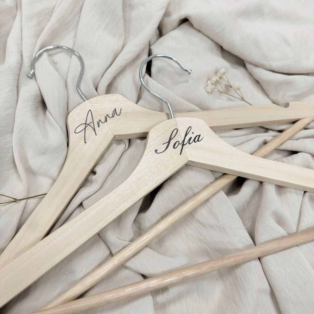 Percha de madera Novellie para colgar ropa, con diseño elegante y resistente para organización en armarios.