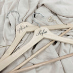 Percha de madera Novellie para colgar ropa, con diseño elegante y resistente para organización en armarios.