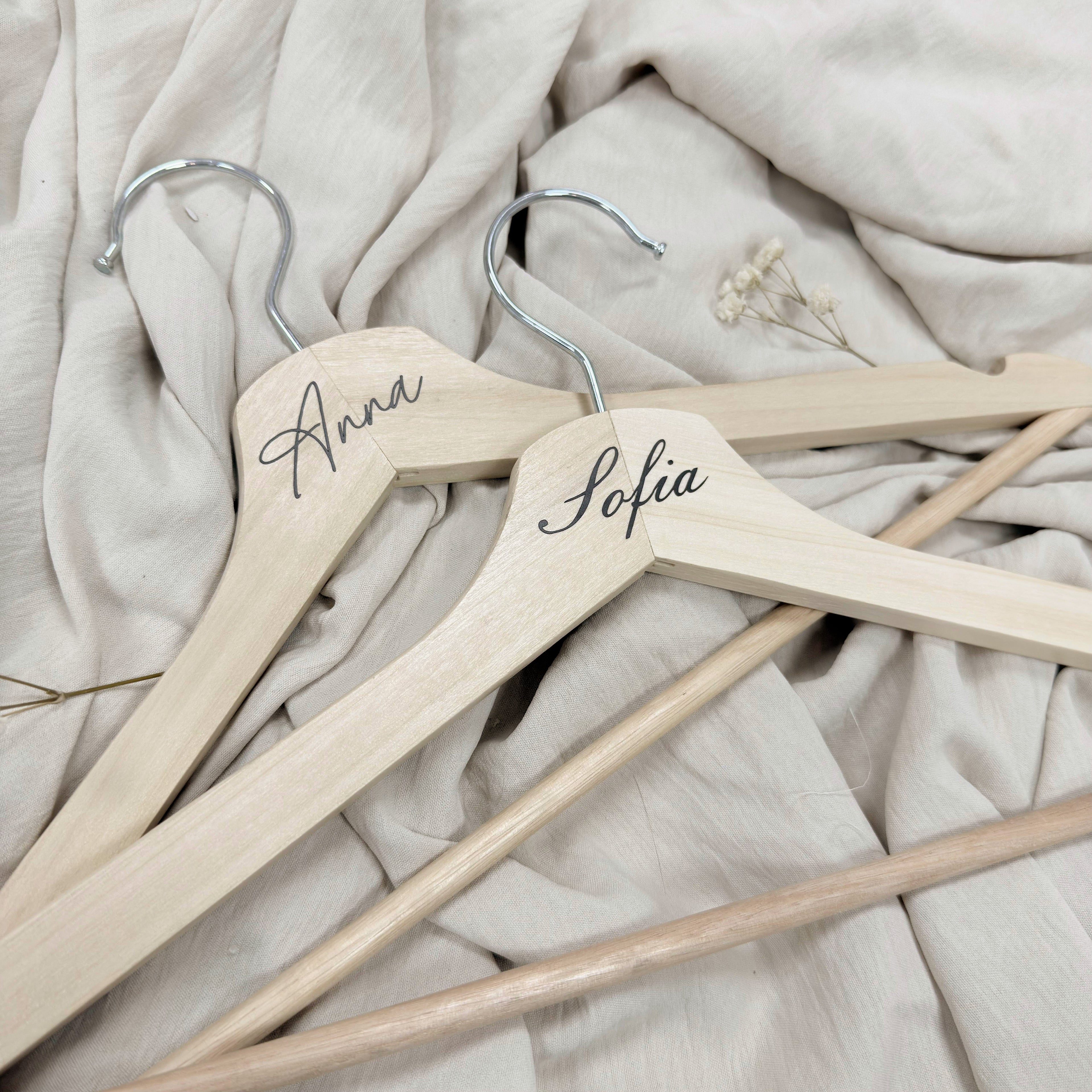 Percha de madera Novellie para colgar ropa, con diseño elegante y resistente para organización en armarios.