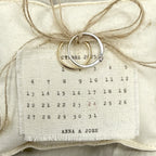 Almohadón calendario Novellie con diseño decorativo, mostrando los días y meses en tela de colores suaves y detalles decorativos.