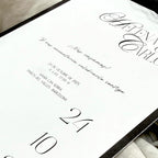 Invitación en marco de la marca Novellie, con diseño elegante y detalles decorativos para eventos especiales.