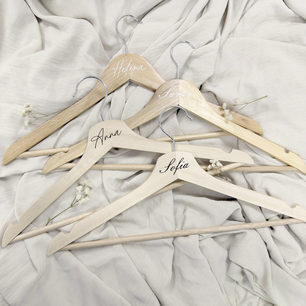 Percha Esencia de Novellie, estructura de madera con gancho metálico, ideal para colgar prendas y accesorios en armario.