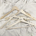 Percha Esencia de Novellie, estructura de madera con gancho metálico, ideal para colgar prendas y accesorios en armario.