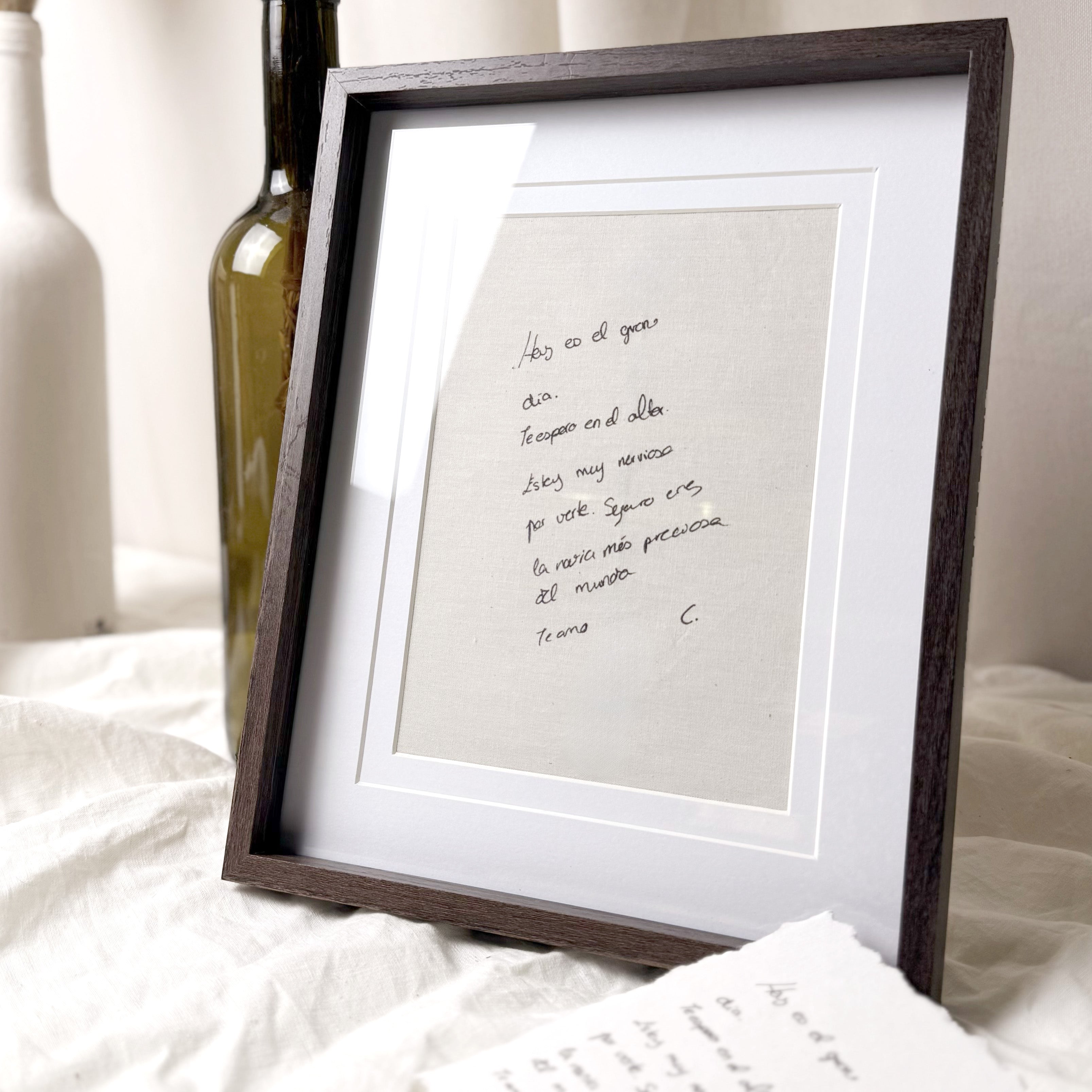 Tarjeta en algodón Novellie con marco, muestra un diseño elegante en tonos neutros sobre fondo blanco.